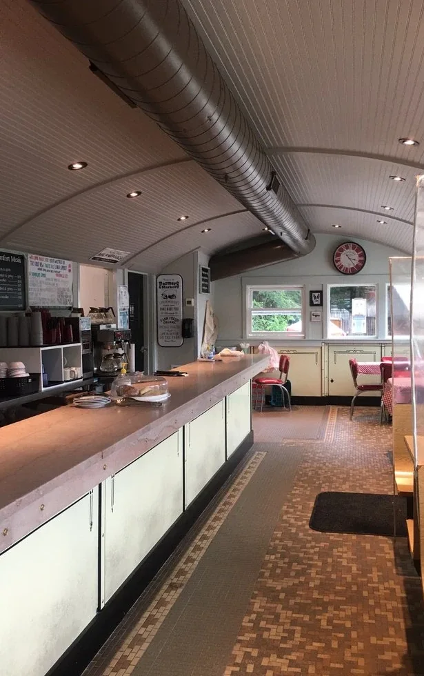 Inside Yankee Diner: the long counter, red-topped stools and booths beneath the curved railcar ceiling.