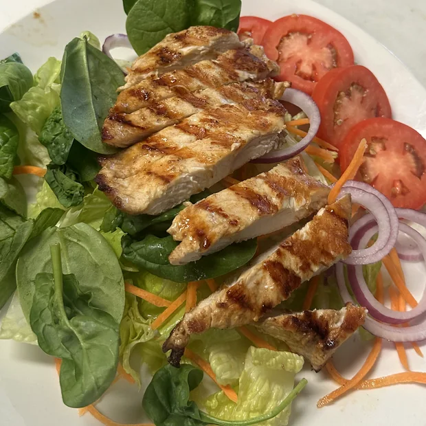 Grilled chicken breast sliced over romaine and spinach with tomato, red onion and shredded carrot.