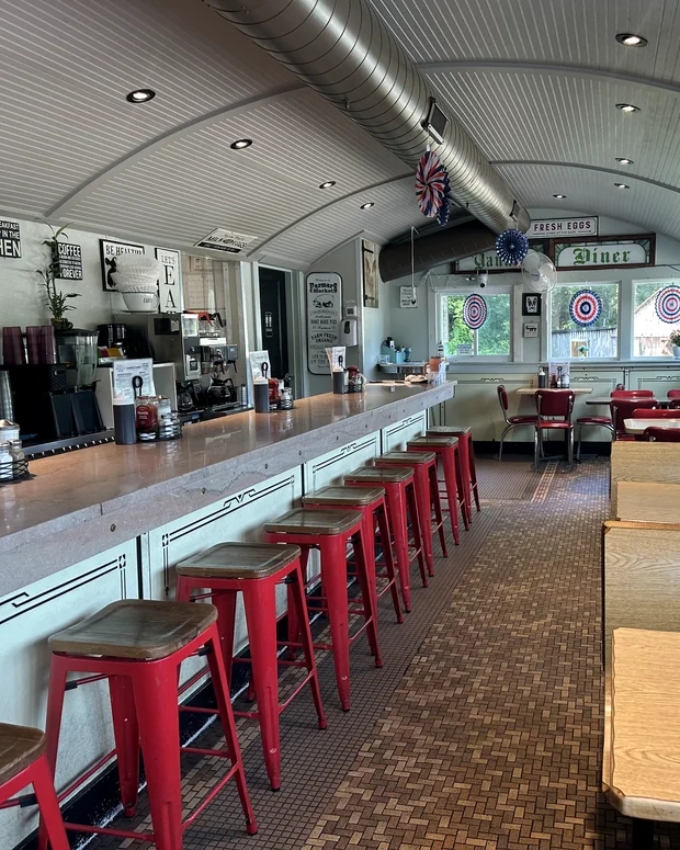 The counter and red stools running the length of the dining car, with the original ribbed barrel ceiling above.
