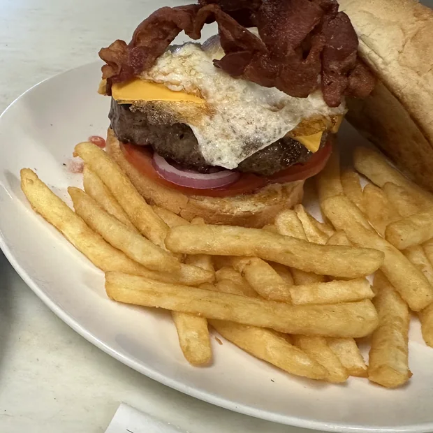 The Yankee Burger: a half pound patty with cheese, bacon and a fried egg on a bulkie roll, served with french fries.